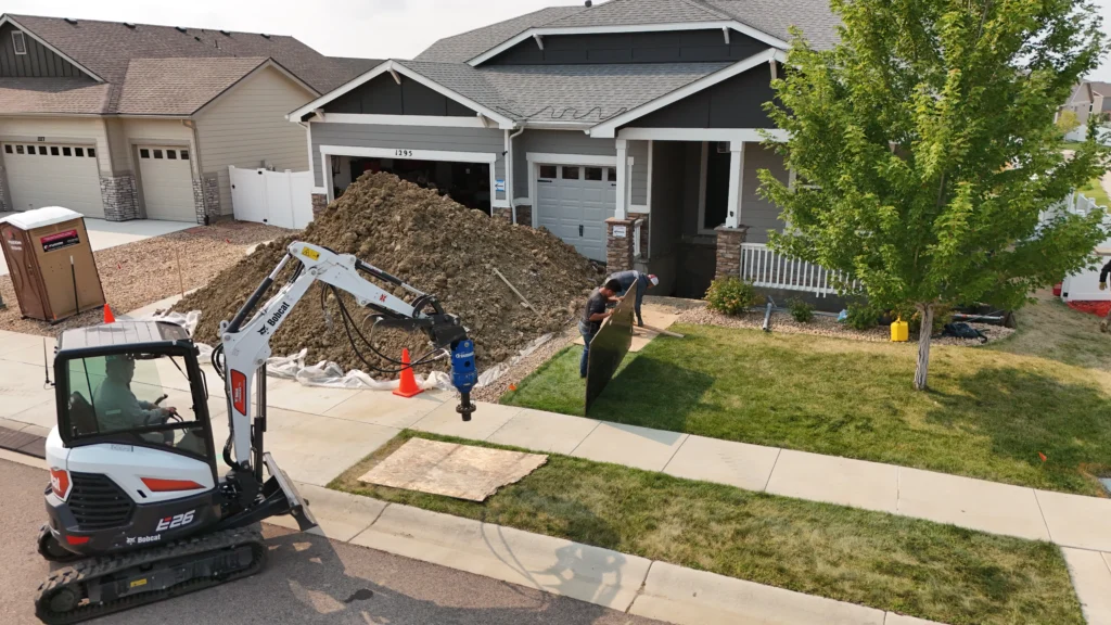 Fort August Construction excavating front porch area and preparing for helical pier drilling with Bobcat excavator