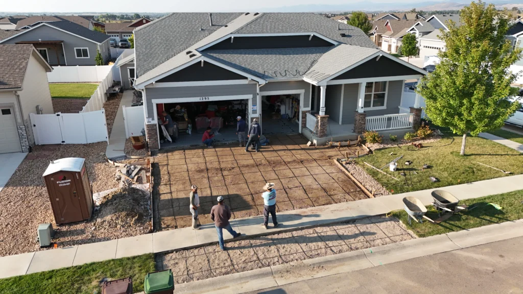 Fort August Construction crew setting up forms and rebar grid for concrete driveway installation