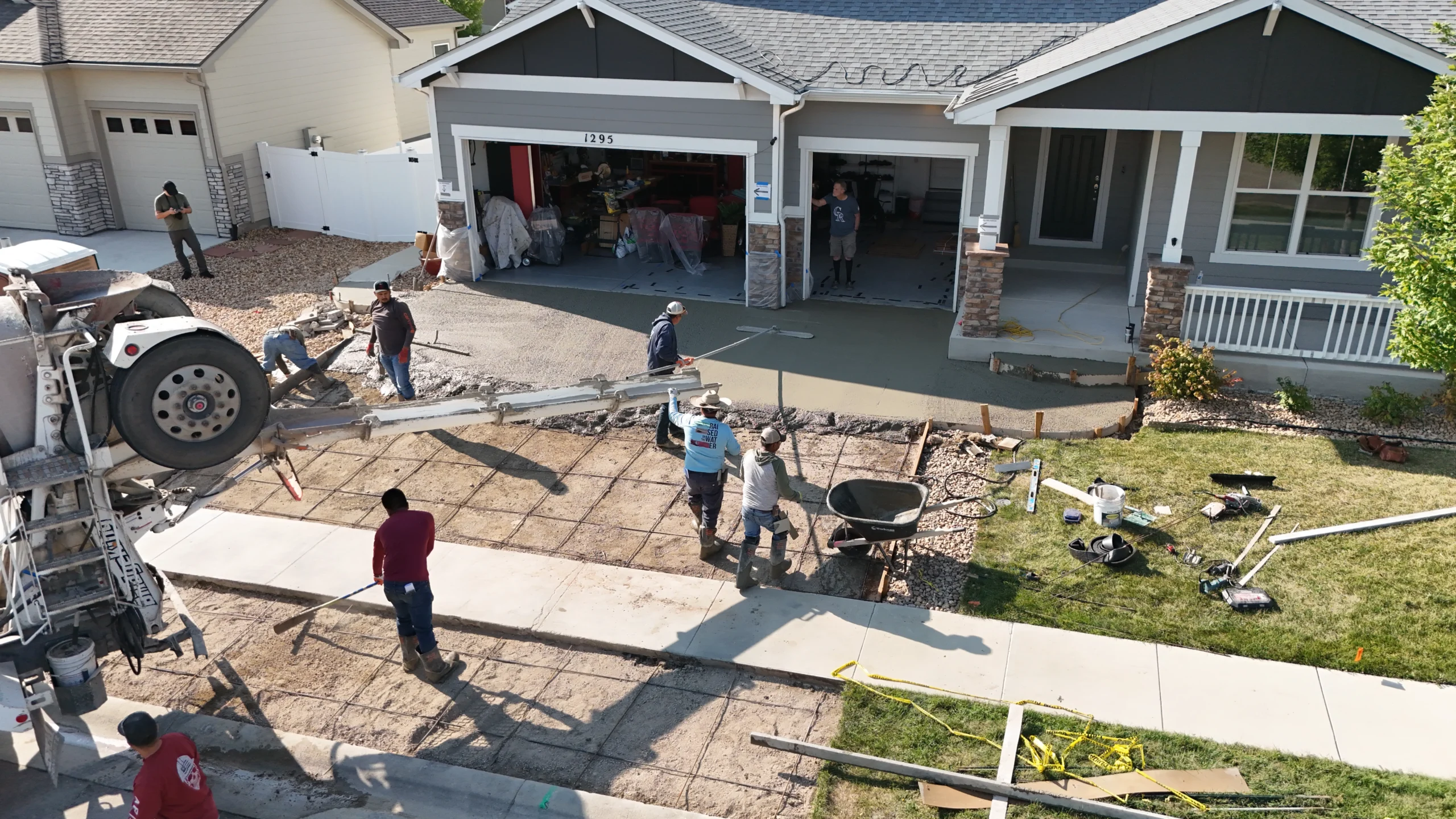 Fort August Construction crew pouring and leveling fresh concrete for a new residential driveway